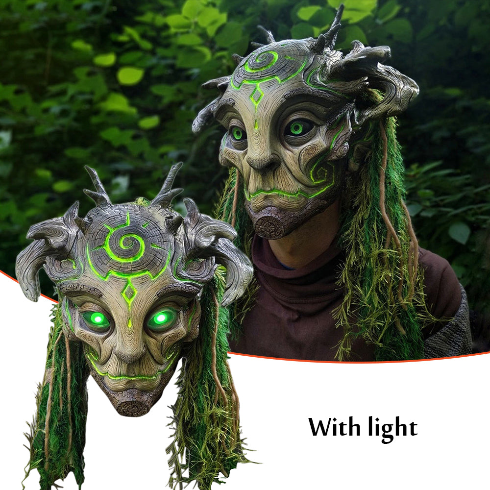 Two fantasy masks with green glowing eyes against a natural background
